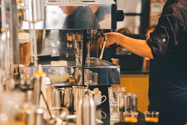 Mujeres Barista para hacer un café en el tono vintage de la cafetería.