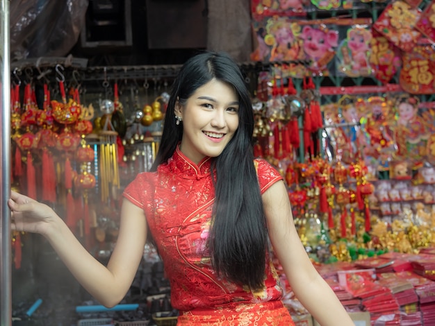 Las mujeres bonitas de la imagen del retrato están llevando el vestido rojo de Cheongsam.