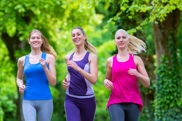 Mujeres en el bosque corriendo por deporte.