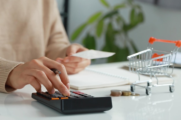 Las mujeres calculan el dinero de la comida con lápiz, papel y calculadora en casa Presupuesto de los desfavorecidos