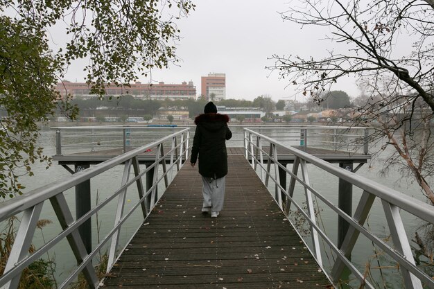 Mujeres caminando por la pasarela del río Guadalquivir caminando hacia atrás