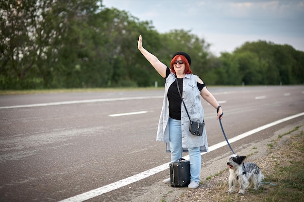 Mujeres en la carretera con perro parado auto