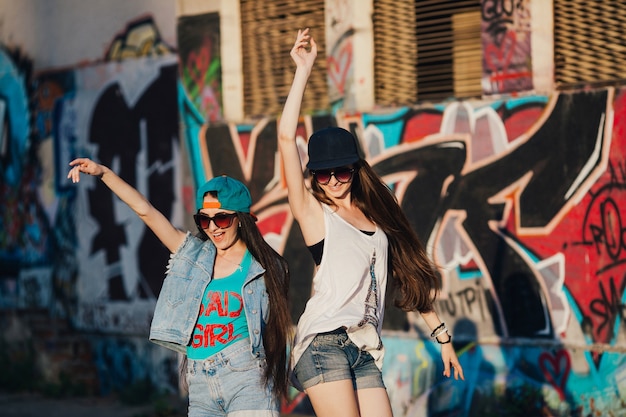 Mujeres casuales que se divierten en la pared urbana