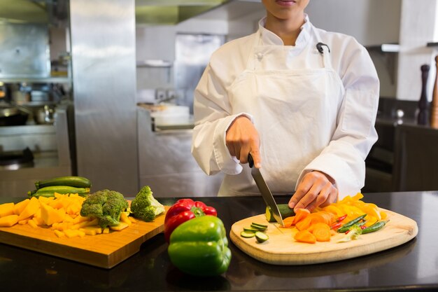 Mujeres chef cortar verduras en la cocina