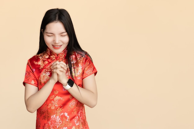 Mujeres chinas vistiendo ropa tradicional Qipao Pide un deseo o reza en el festival del Año Nuevo Chino con espacio de copia.