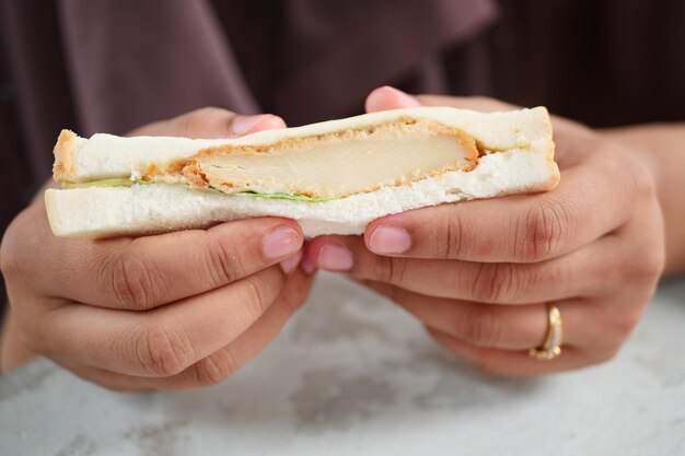 Mujeres comiendo sándwich de pollo de cerca