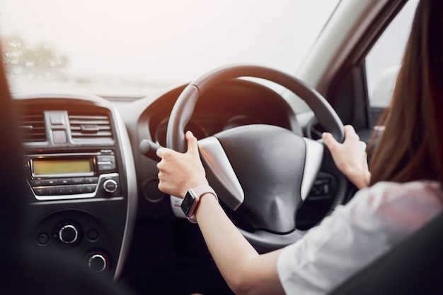 las mujeres conducen un carro. la vista posterior puede mirar hacia el frente en la misma vista que el conductor.