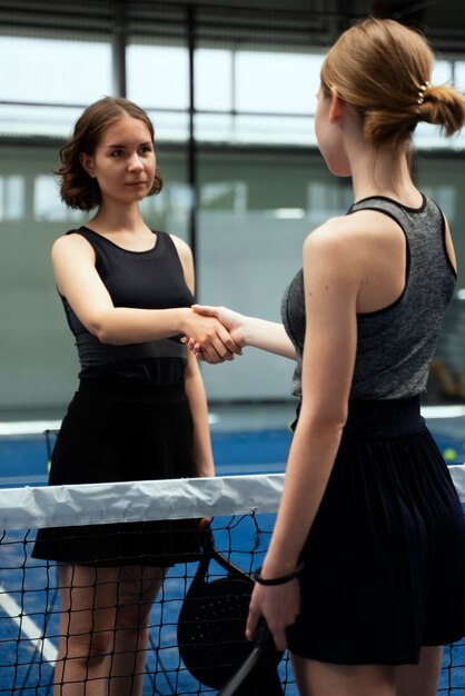 Foto mujeres dándose la mano tiro medio