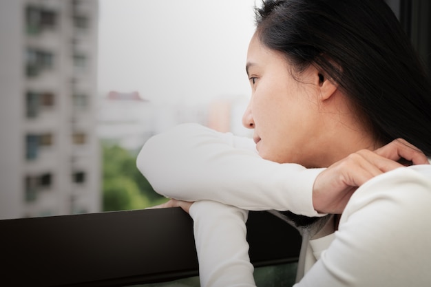 Mujeres deprimidas que se sientan cerca de la ventana, solo, tristeza, concepto emocional