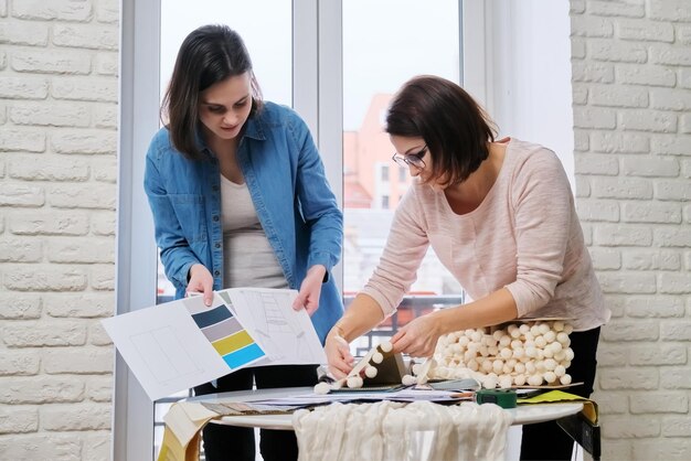 Mujeres diseñadoras que trabajan en diseño de interiores eligiendo muestras de telas