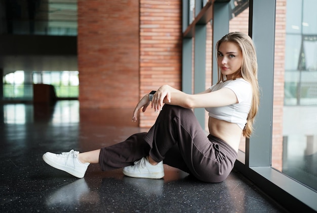 Las mujeres disfrutan posando en un lugar blanco mínimo. Lugar y fondo blancos mínimos y hermosa dama caucásica rubia en el interior de un café mínimo.