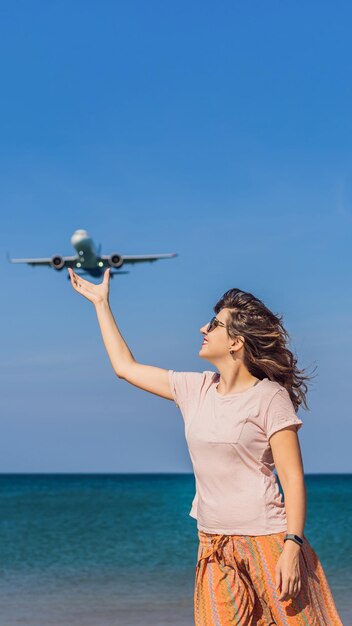 Las mujeres se divierten en la playa viendo los aviones que aterrizan viajando en un espacio de texto de concepto de avión