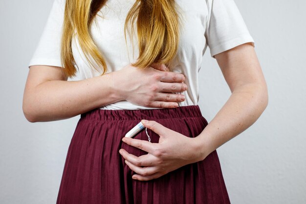 Foto mujeres con dolor abdominal y un tampón en las manos menstruación ginecología