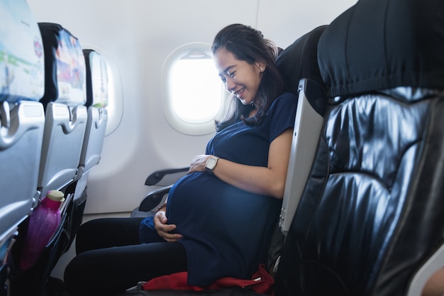 Las mujeres embarazadas asiáticas disfrutan de viajar en avión