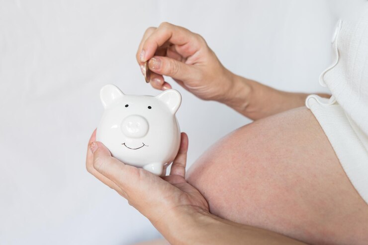 Mujeres embarazadas con camisas blancas ponen monedas en la alcancía ahorrando dinero para su concepto de bebé recién nacido