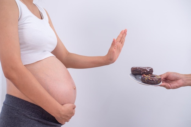 Las mujeres embarazadas se esfuerzan por controlar su nivel de azúcar para no desarrollar diabetes durante el embarazo Las mujeres embarazadas se niegan a comer donas y alimentos que contengan cafeína