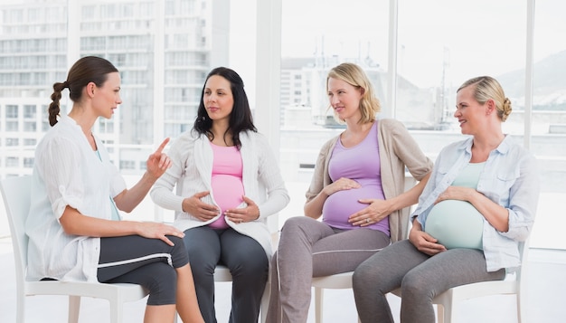 Mujeres embarazadas hablando juntas en la clase prenatal