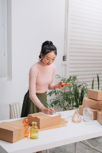 Mujeres empacando paquetes con sus productos que vende en línea