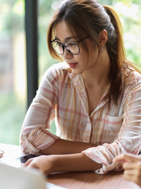 Mujeres empresarias en busca de su computadora portátil en la sala de reuniones