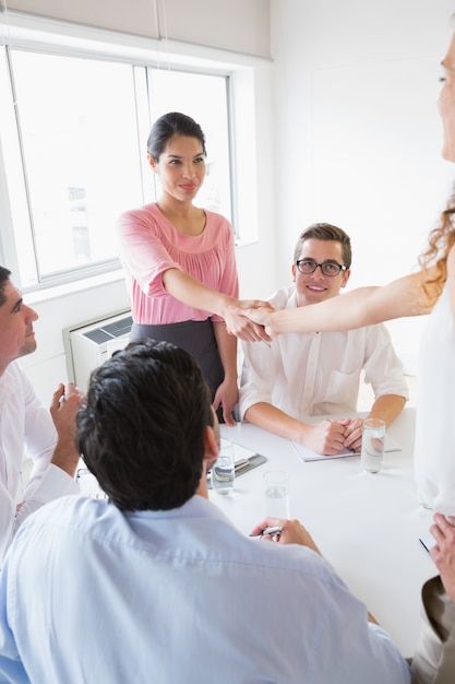 Mujeres empresarias dándose la mano durante la reunión