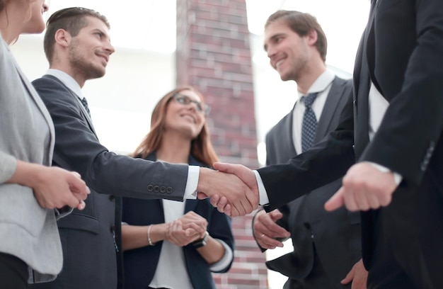 Mujeres empresarias felices dándose la mano en la oficina