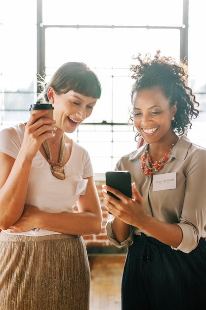 Mujeres empresarias que comparten contenido en línea desde un teléfono