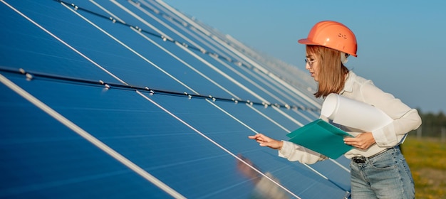 Mujeres empresarias que trabajan en el control de equipos en la planta de energía solar con lista de verificación de tabletas mujer que trabaja al aire libre en la planta de energía solar