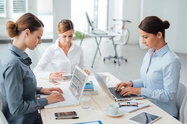 Mujeres empresarias seguras que trabajan en el escritorio