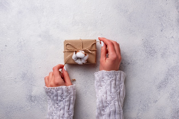 Mujeres envolviendo cajas de regalos en papel artesanal.