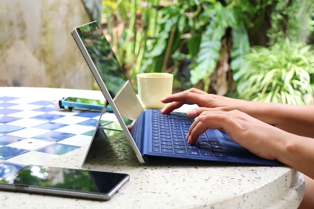 Mujeres escribiendo en el teclado de la computadora portátil Trabajar desde casa para prevenir la infección de Covid19