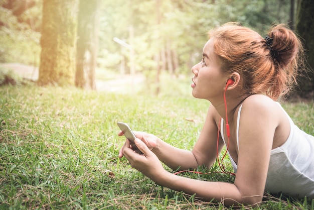 Las mujeres escuchan música Relájate en el parque natural.