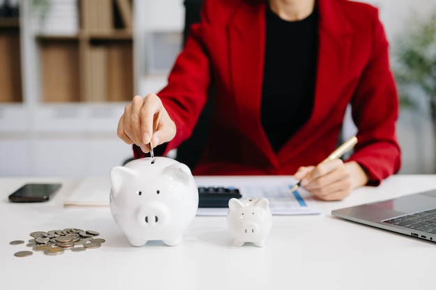 Foto las mujeres están poniendo monedas en una alcancía para un negocio que crece con fines de lucro y ahorro de dinero f