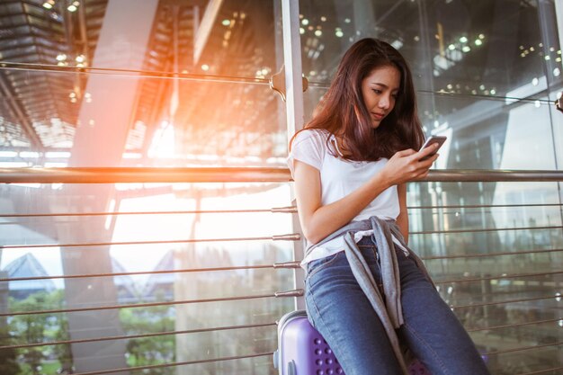 Las mujeres están usando sus teléfonos inteligentes para la verificación de vuelos en los aeropuertos y el concepto de tecnología