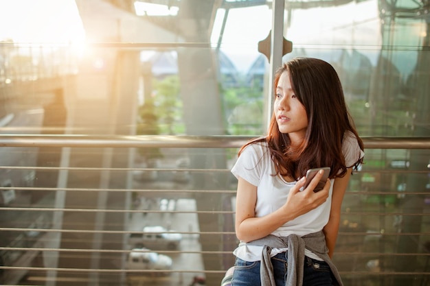 Las mujeres están usando sus teléfonos inteligentes para la verificación de vuelos en los aeropuertos y el concepto de tecnología