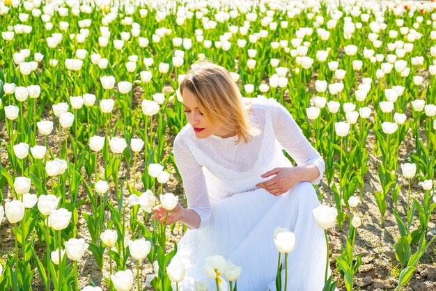 Las mujeres de estilo de vida que se sienten bien se relajan y la libertad feliz en la granja de tulipanes de la naturaleza.