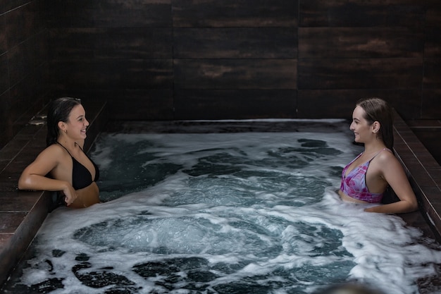 Mujeres felices disfrutando juntos del baño de hidroterapia