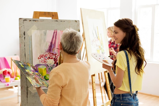 Foto mujeres felices pintando en el estudio de la escuela de arte