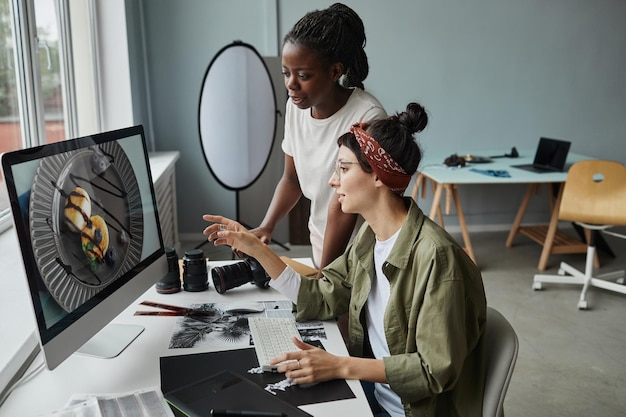 Mujeres fotógrafas discutiendo la foto en la pantalla