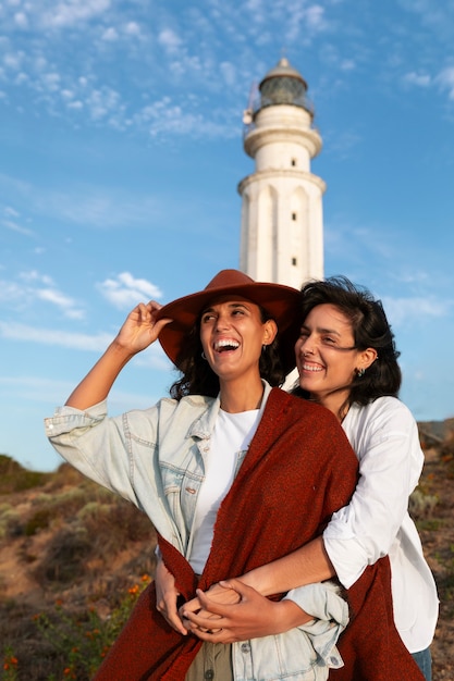 Foto mujeres de frente posando con un faro