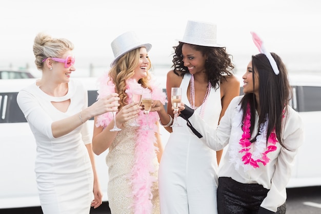 Foto mujeres frívolas bebiendo champaña en una limusina