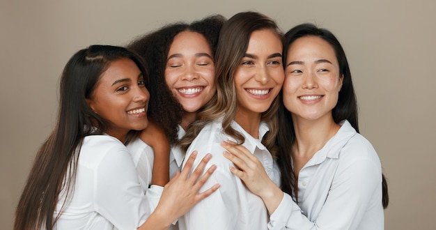 Mujeres grupo cuidado de la piel y belleza con amor abrazo y apoyo en la diversidad y la inclusión en fondo de estudio marrón Amigos modelo o personas sonríen juntos y besan en dermatología cuidado de la piel o maquillaje