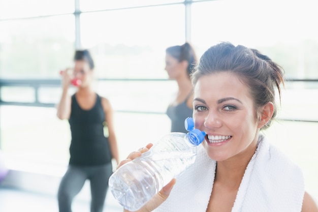 Foto mujeres hablando mientras otro agua potable en el gimnasio