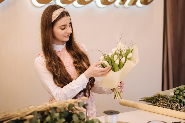 Las mujeres hacen jardineros de ramo de primavera en la florería hacen que la floristería de estilo de vida de ramo sea hermosa