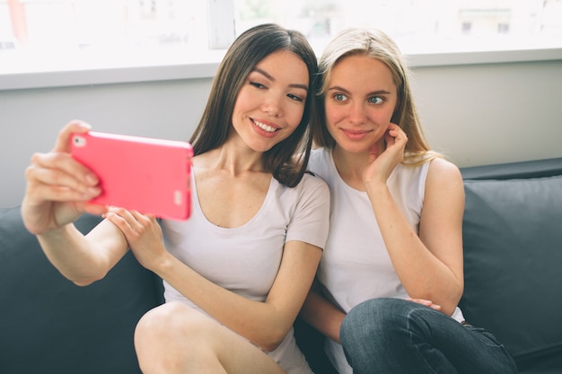 Mujeres haciendo selfie en casa.