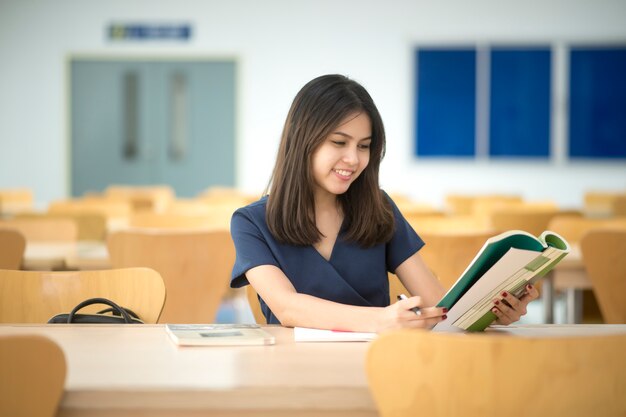 Mujeres hermosas estudiantes universitarios asiáticos en la biblioteca