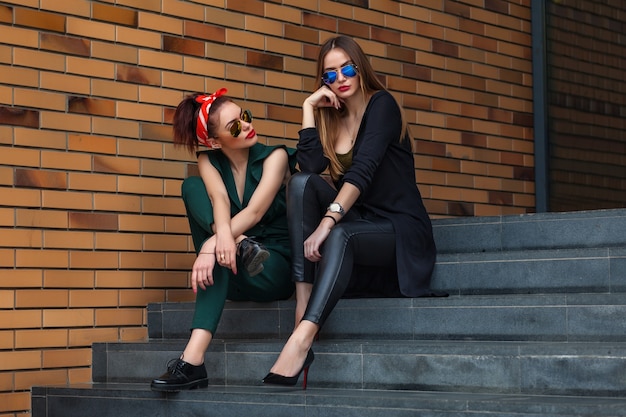 Mujeres hermosas de la manera que presentan en el fondo de la ciudad.