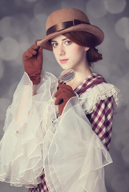 Mujeres hermosas pelirrojas con lupa. Foto de estilo retro con bokeh de fondo.