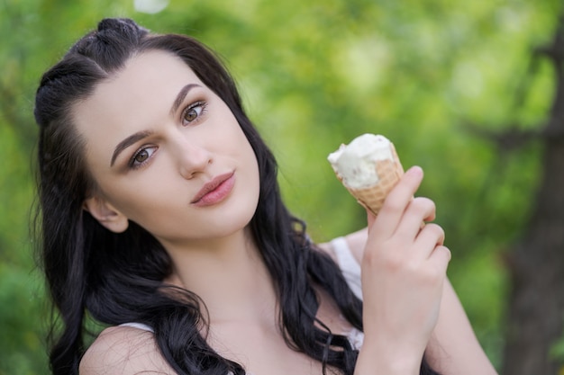 Mujeres hermosas que comen un helado en el parque. Concepto de juventud.