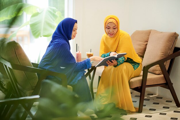 Mujeres en hijabs discutiendo un libro interesante