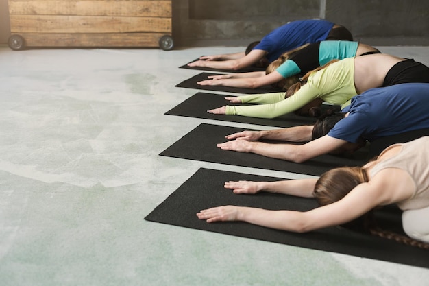 Mujeres y hombres jóvenes en clase de yoga, ejercicios de meditación. Posa para la relajación. Estilo de vida saludable en el gimnasio, cultivo, espacio de copia